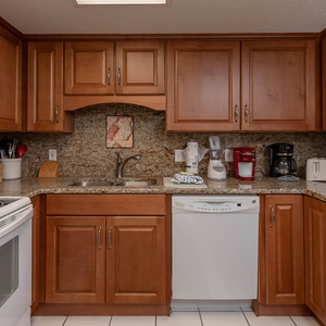 Granite countertops complement this kitchen, featuring essential appliances, a Keurig, coffe maker, and a breakfast bar
