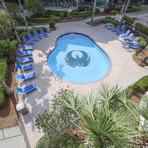 Relax on a lounge chair by the sparkling pool, soaking up the sun and enjoying the lush surroundings