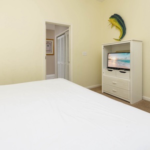 Brightly colored fish decor accents a cozy guest room featuring a TV and queen bed, creating a welcoming retreat