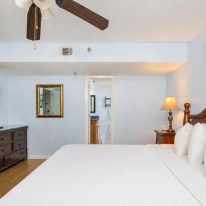 Plush king bed awaits your rest while soft lamp light creates a peaceful bedroom retreat