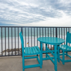 Relax at the turquoise table set, enjoying refreshing views of the waves and beach from your comfortable spot