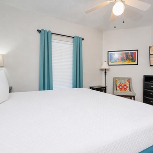 King bed in the guest suite invites you to unwind while watching a peaceful beach sunset on TV