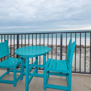 Sit at the turquoise table and chairs on the balcony, enjoying views of the tranquil waters and shoreline