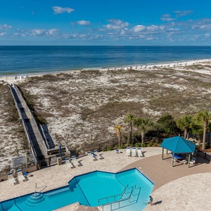 Take a refreshing dip in the pool while enjoying views of the beach and the inviting boardwalk leading to the shore
