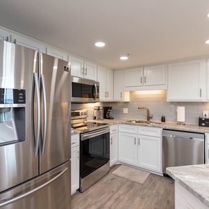 Prepare meals with ease in this stylish kitchen featuring stainless appliances and elegant countertops