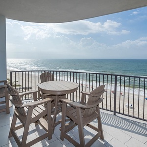 Relax at the outdoor table with seating, enjoying the view of the beach and waves just steps away