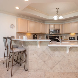 Gather around the sleek breakfast bar, featuring stylish seating and a vibrant fish artwork that adds charm to your stay
