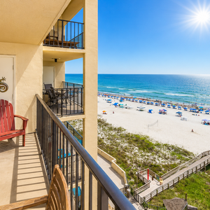 Watch families enjoy the beach under colorful umbrellas from your relaxing balcony