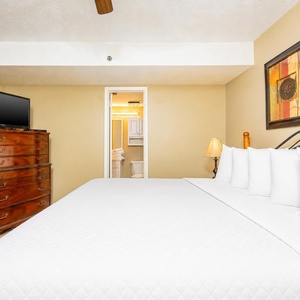 This cozy bedroom features a comfortable king bed, a flat-screen TV, and a warm color palette, creating a relaxing retreat