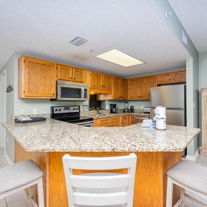 Gather around the granite breakfast bar, perfect for coffee and conversation in this inviting kitchen