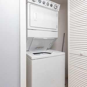 Convenient laundry area featuring a stacked washer and dryer, ideal for keeping your vacation wardrobe fresh and clean
