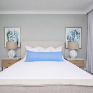 Relax in this serene master bedroom in a king bed with soft linens and coastal artwork for a restful retreat
