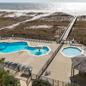 Inviting pool area features a spacious and sparkling pool, a fun water feature, and lounge chairs surrounded by lush greenery