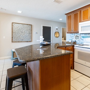 Gather around the sleek granite counter, enjoying meals and conversations in this inviting kitchen space