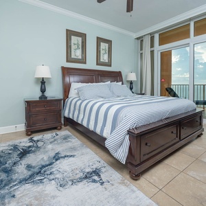 Relax in the serene master suite featuring a cozy king bed, stylish decor, and beachfront balcony access