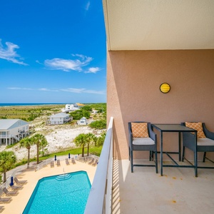 This bright space offers a stunning beach view with palm trees framing the pool area, perfect for relaxation and enjoyment