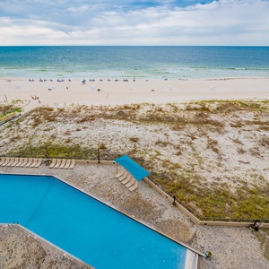 Refreshing gradual entry poolside view with lounge chairs, just steps from the beach for a relaxing day in the sun