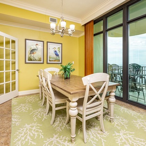 Sunlight warms the dining room as you gather around the sturdy table with coastal views beyond sliding glass doors