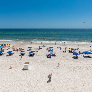 Enjoy a vibrant beachfront view with colorful umbrellas and families relaxing on the soft white sand