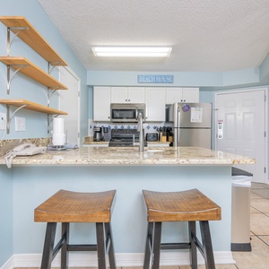 Modern and elegant kitchen featuring stainless appliances, granite countertops, and inviting bar stools for casual dining