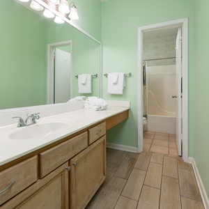 Refresh in the master bathroom featuring a spacious vanity, ample towels, and a relaxing tub for your comfort