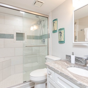 Refresh in the guest bath shower with elegant tile accents and a stylish vanity featuring a sleek countertop