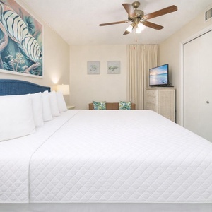 Relax in the king suite, enjoying the serene beach vibe while catching up on your favorite shows