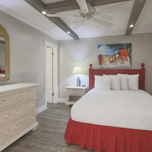 This guest bedroom features a vibrant red bed, stylish decor, and a cozy atmosphere perfect for relaxation