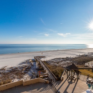 Experience breathtaking views from your balcony overlooking the serene beach and inviting pool area, perfect for relaxation