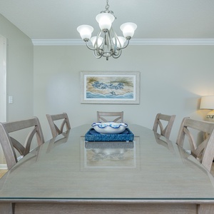 Dine comfortably at the elegant table, adorned with coastal decor, perfect for meals and gatherings