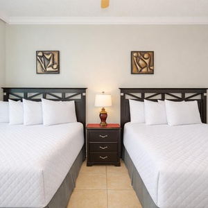 Guest bedroom featuring two comfortable double beds and modern artwork, perfect for a restful getaway