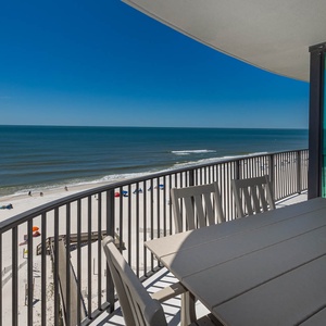 Savor meals or drinks on the spacious balcony while enjoying expansive views of the tranquil shoreline and gentle waves