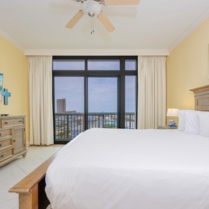 Comfy master suite featuring a king bed, balcony with a scenic view, and a mounted TV for entertainment