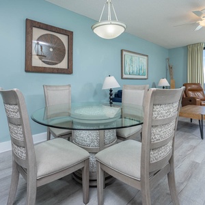 Gather around the glass table, enjoying views through large windows while relaxing in stylish seating