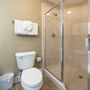 Refresh after a day at the beach in this guest bathroom, featuring plush towels and a spacious shower