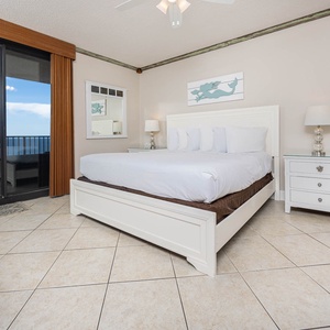Unwind in the serene master suite featuring a comfortable king bed, stylish decor, and beachfront balcony access