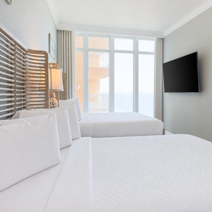 Wake to a breathtaking sunrise in this queen guest suite with two cozy beds and expansive views from the windows