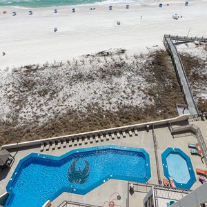 Cool pool water sparkles as you lounge nearby while the beach path invites your next stroll on the shore