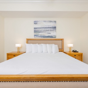 Relaxing master bedroom featuring a king bed, stylish lamps, and soothing artwork above the headboard