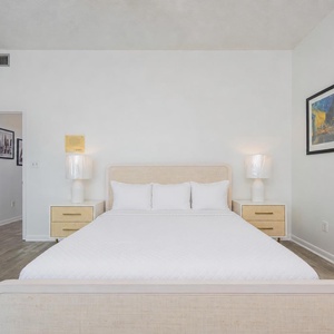 Guest bedroom featuring a cozy queen bed with plush pillows and stylish nightstands, perfect for restful stays