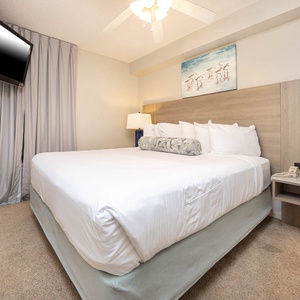 Retreat to this serene bedroom featuring a king bed, soft linens, and a flat-screen TV for your comfort