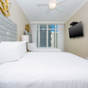 Relax in this guest bedroom featuring two queen beds, a TV, and large windows for stunning views