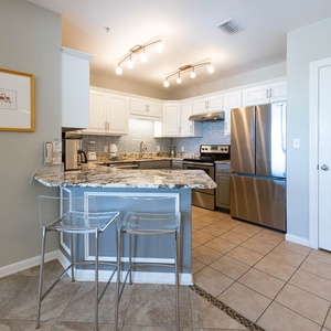 Enjoy cooking in this stylish kitchen featuring granite countertops, stainless steel appliances, and modern lighting