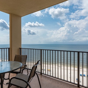 Relax on the balcony with a glass table and chairs, enjoying the serene beachfront view and gentle waves below