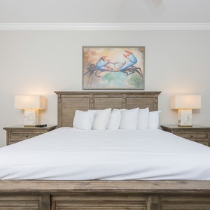 Sleep peacefully on plush king bedding, surrounded by soft lighting and cheerful beach accents