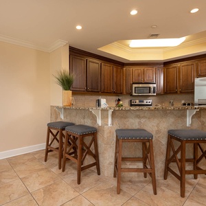 The kitchen features rich wooden cabinetry, granite countertops, and stainless appliances, perfect for culinary adventures