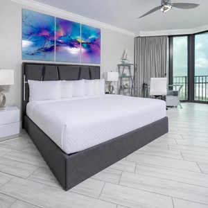 Enjoy restful nights in this stunning master suite featuring a plush king bed, trendy decor, and beachfront balcony