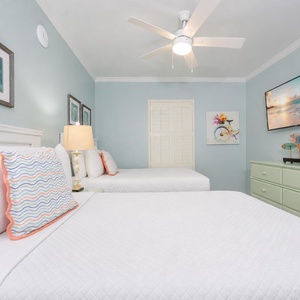 The guest suite with two doubles invites you to relax beneath the ceiling fan while streaming your favorite show on the TV