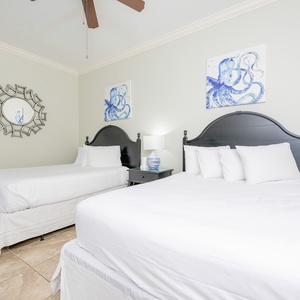 Cheerful guest bedroom featuring two cozy queen beds, elegant decor, and charming octopus artwork on the walls