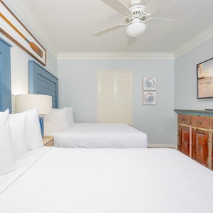 Blue and white linens welcome you to the guest suite with two queen beds and a TV for relaxing evenings
